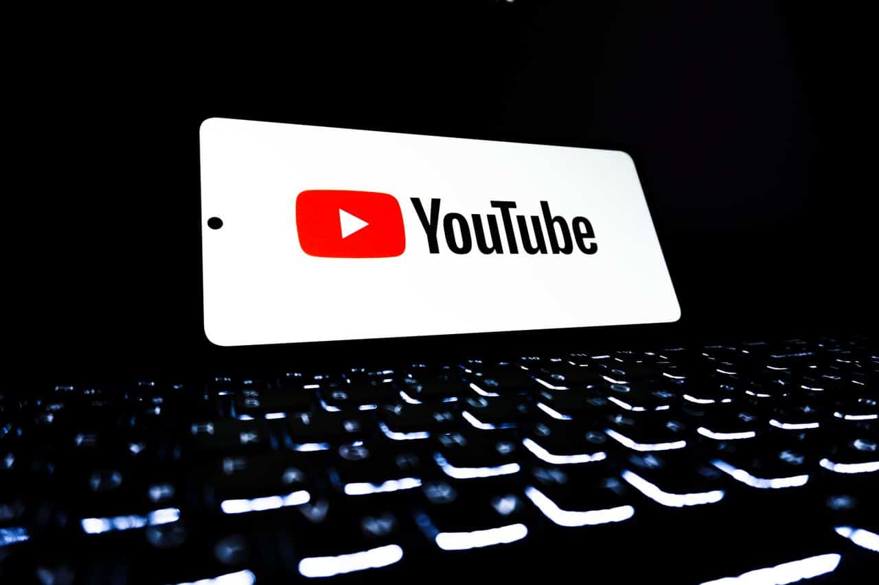 شعار يوتيوب على بطاقة بيضاء فوق لوحة مفاتيح مضيئة، يرمز إلى إعلانات يوتيوب